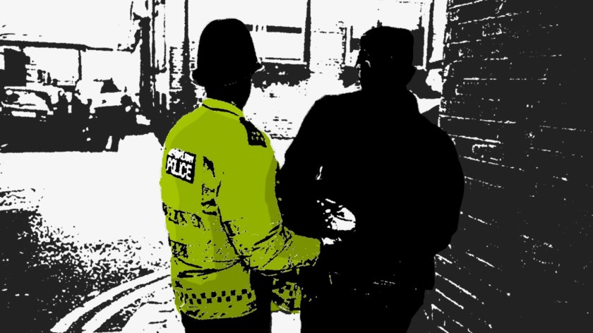 Picture of a police officer arresting a man.